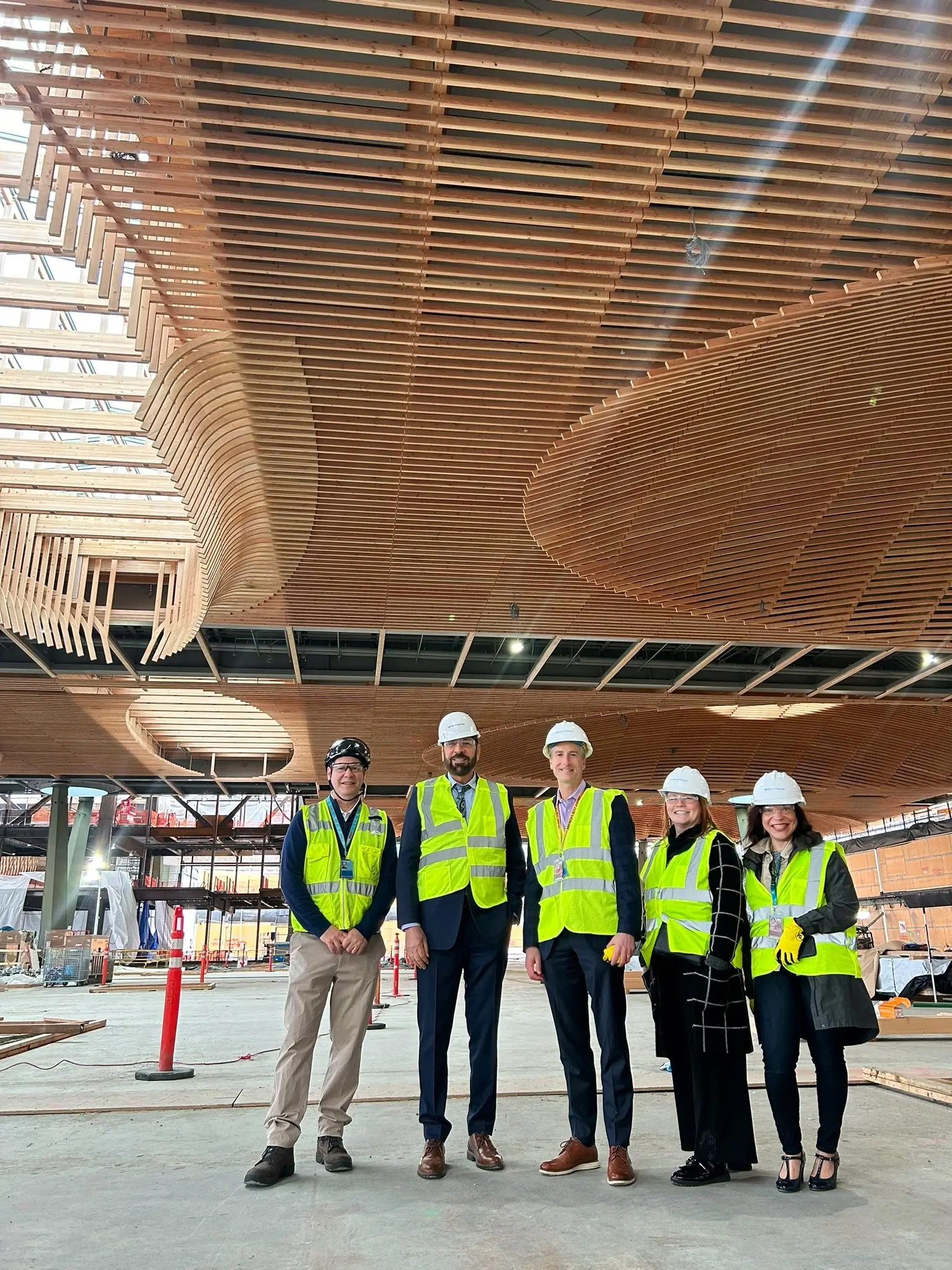 El ministro Jagrup Brar es fotografiado con varios colegas en una nueva sección del aeropuerto de Portland, Oregón, que cuenta con construcción masiva de madera.